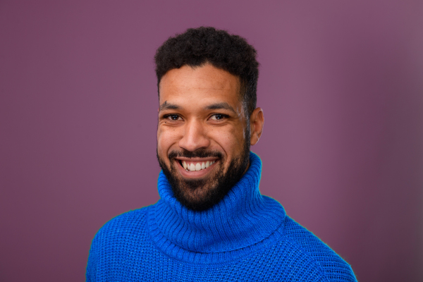 Portrait of happy multiracial man in blue knitted sweater.