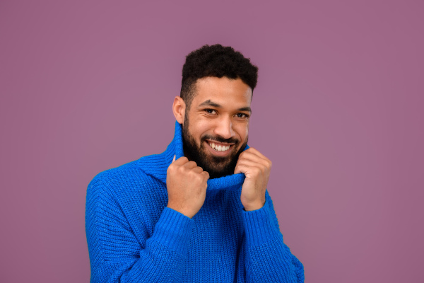 Portrait of happy multiracial man in blue knitted sweater.