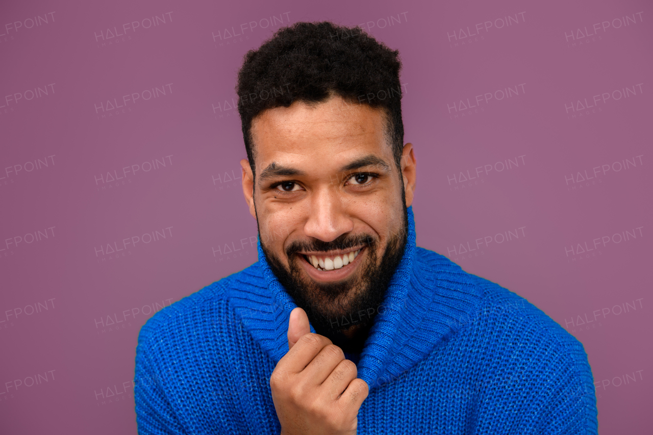 Portrait of happy multiracial man in blue knitted sweater.