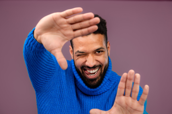 Portrait of happy multiracial man in blue knitted sweater.