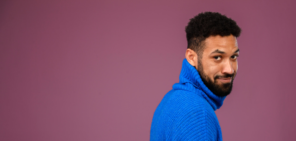 Portrait of happy multiracial man in blue knitted sweater.