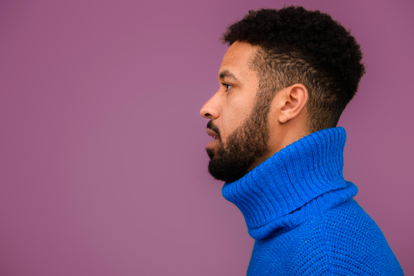 Portrait of multiracial man in blue knitted sweater.