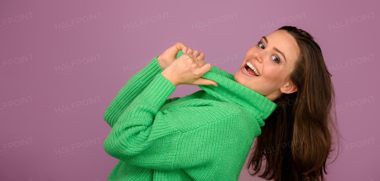 Young happy woman posing in sweater during studio shooting.