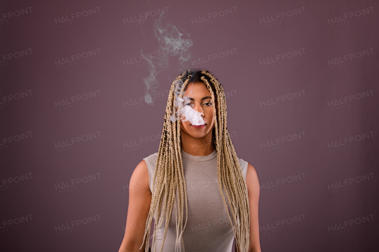 Portrait of multiracial woman smoking, studio shoot.