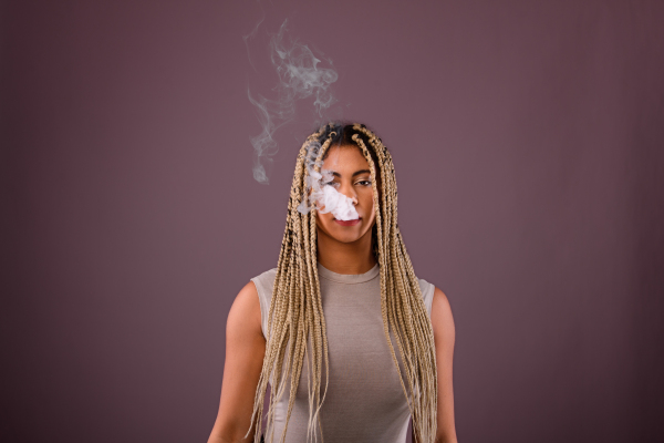 Portrait of multiracial woman smoking, studio shoot.