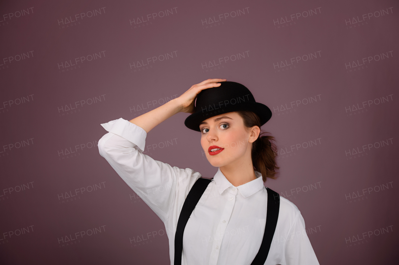 Portrait of a happy young woman in hat, studio shoot.