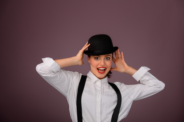 Portrait of a happy young woman in hat, studio shoot.