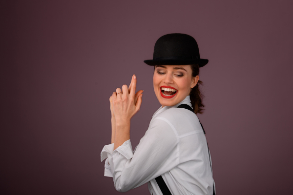 Portrait of a happy young woman in hat, studio shoot.