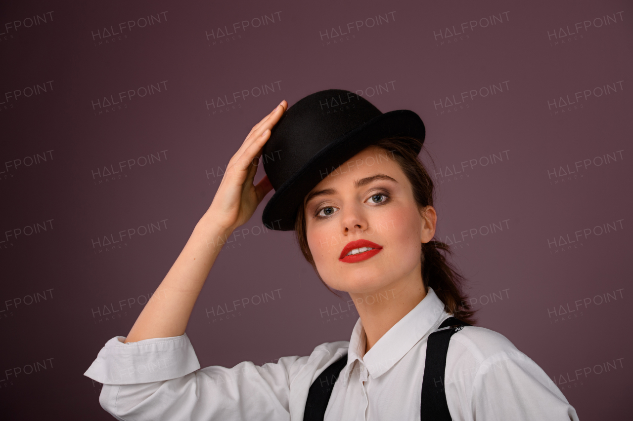 Portrait of a happy young woman in hat, studio shoot.