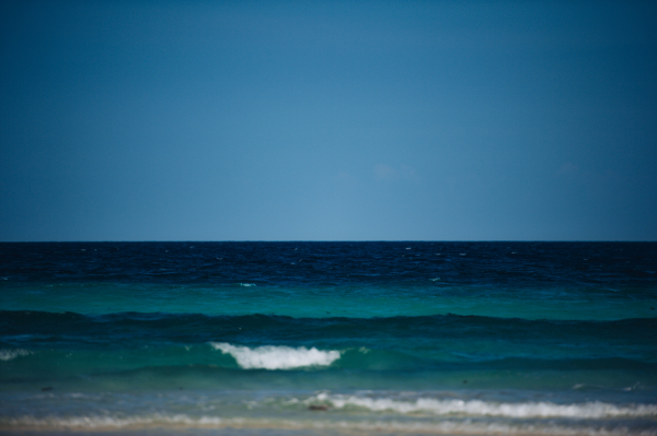 Stunning view from Mnemba beach to the Indian Ocean. Scenery with coastline, sea and blue sky from Zanzibar island with worlds most beautiful beaches.