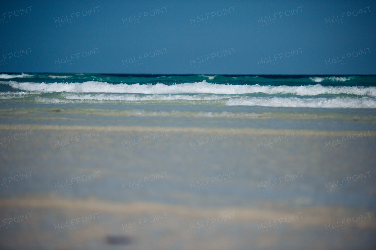 Stunning view from Mnemba beach to the Indian Ocean. Scenery with sand, coastline, sea and blue sky from Zanzibar island with worlds most beautiful beaches.