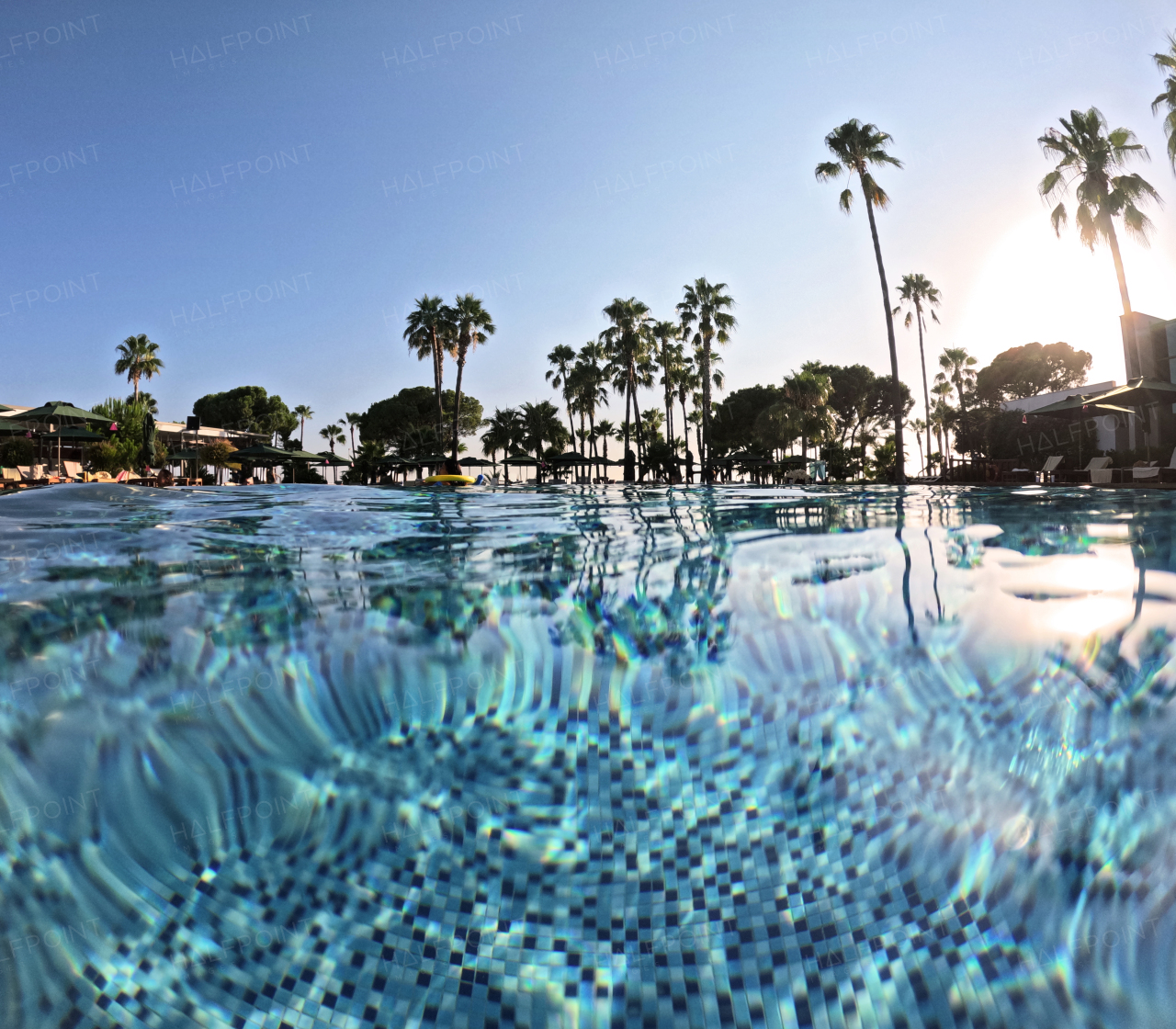 Over-under shot of a hotel pool in a beach resort with copy space. Beach resort vacation by the sea. Winter or summer seaside resort holiday.