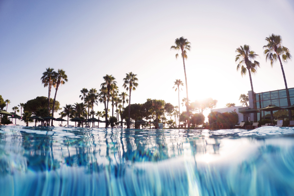 Over-under shot of a hotel pool in a beach resort with copy space. Beach resort vacation by the sea. Winter or summer seaside resort holiday.