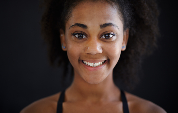 A beautiful teenage Afro American girl with piercing in lips looking at camera and smiling