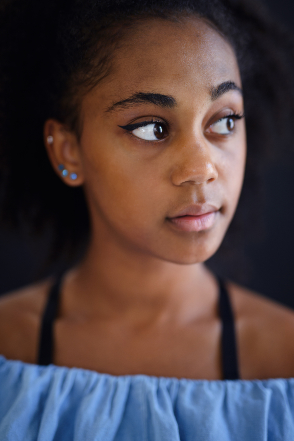 A portrait of sad beautiful teenage African American girl looking away