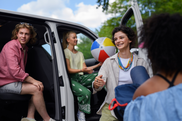 A multiracial young friends travelling together by car - summer vacation, holidays, travel and road trip concept.