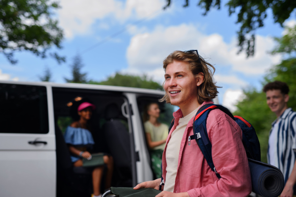 A multiracial young friends travelling together by car - summer vacation, holidays, travel and road trip concept.