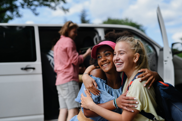 A multiracial young friends travelling together by car - summer vacation, holidays, travel and road trip concept.