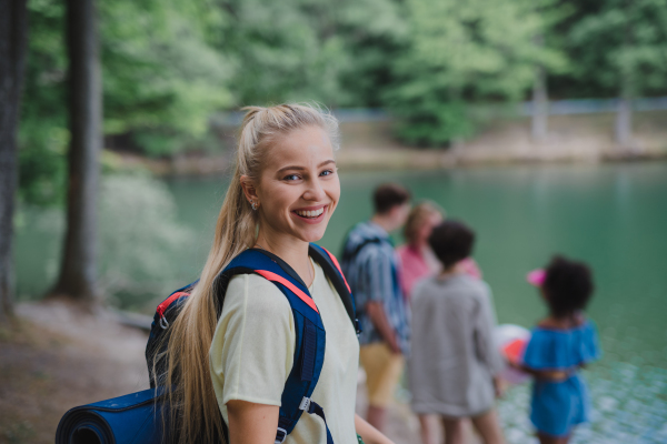 A young woman with friends on a hiking or camping trip in the mountains in summer.