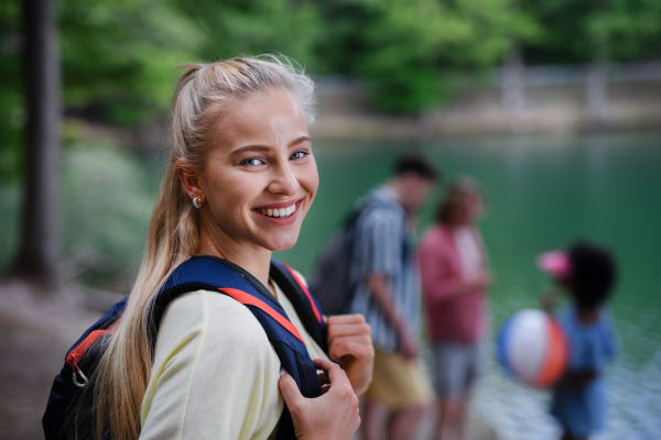 Young woman with friends on camping trip at the lake in summer.