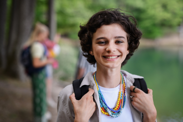 Portrait of young woman with friends on camping trip at the lake in summer.