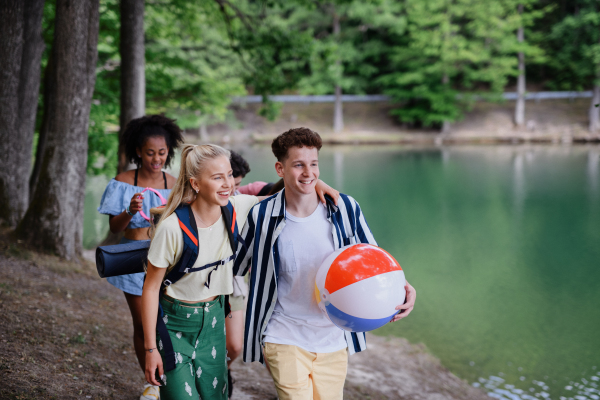 A group of young friends on camping trip near lake in summer.