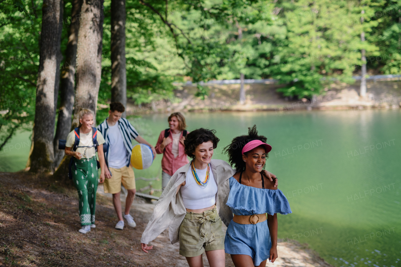 A group of young friends on camping trip near lake in summer.