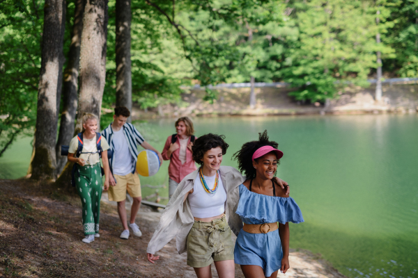 A group of young friends on camping trip near lake in summer.