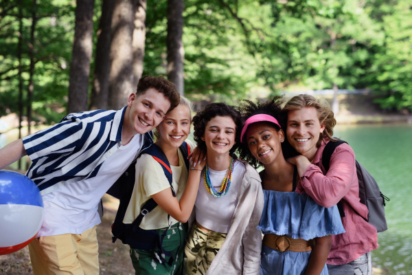 A group of young friends on camping trip near lake in summer.