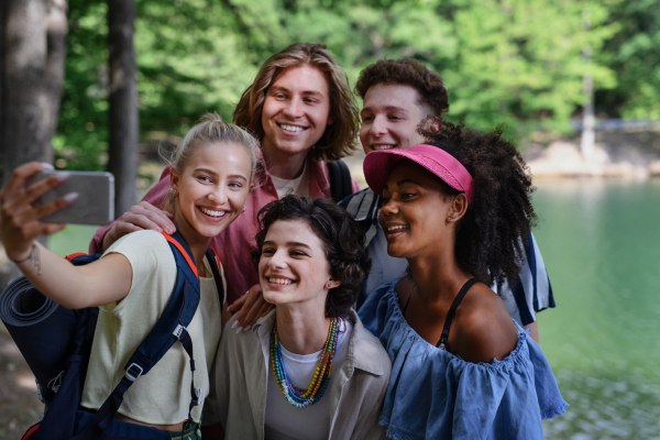 A group of young friends on camping trip near lake in summer.