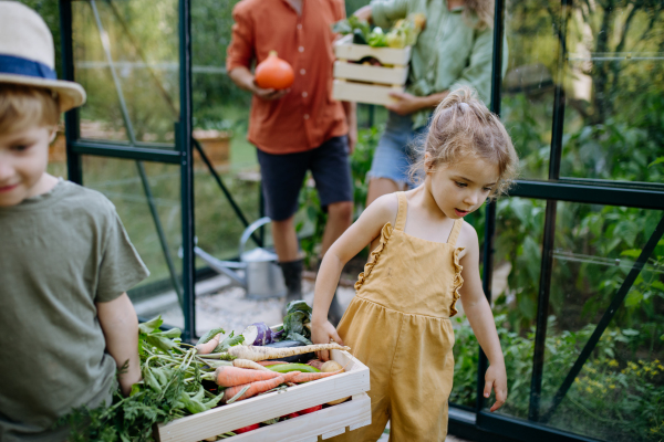 A farmer family with fresh harvest standing in a greenhouse