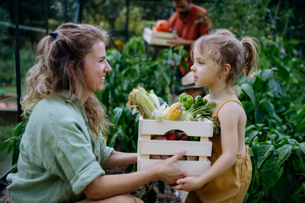 A farmer family with fresh harvest standing in a greenhouse