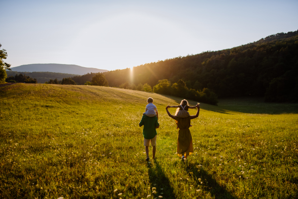 A happy young family spending time together outside in green nature.