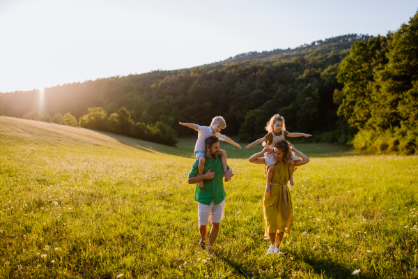 A happy young family spending time together outside in green nature.