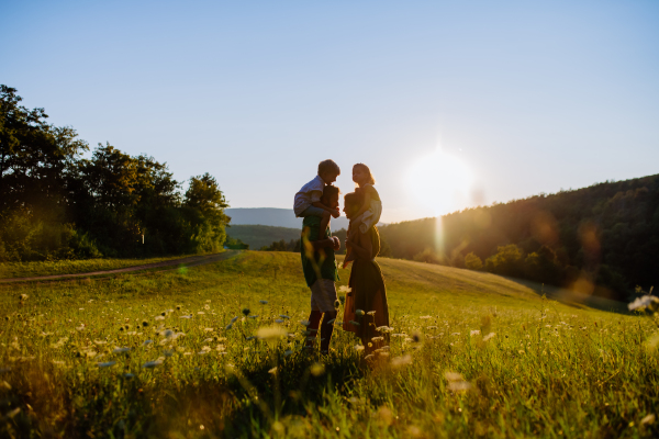 A happy young family spending time together outside in green nature.