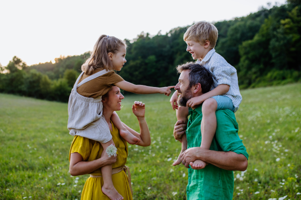 A happy young family spending time together outside in green nature.