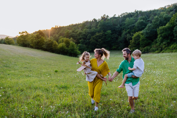 A happy young family spending time together outside in green nature.