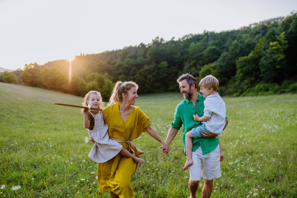 A happy young family spending time together outside in green nature.