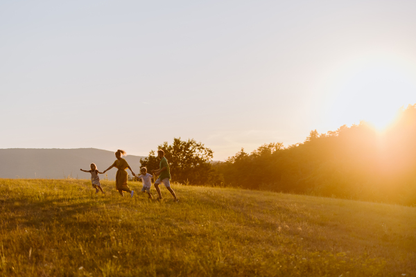 A happy young family spending time together outside in green nature.