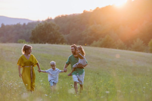 A happy young family spending time together outside in green nature.