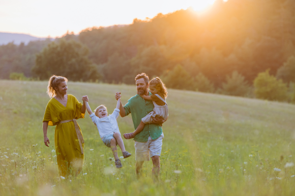 A happy young family spending time together outside in green nature.