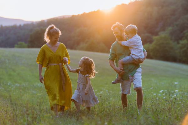 A happy young family spending time together outside in green nature.