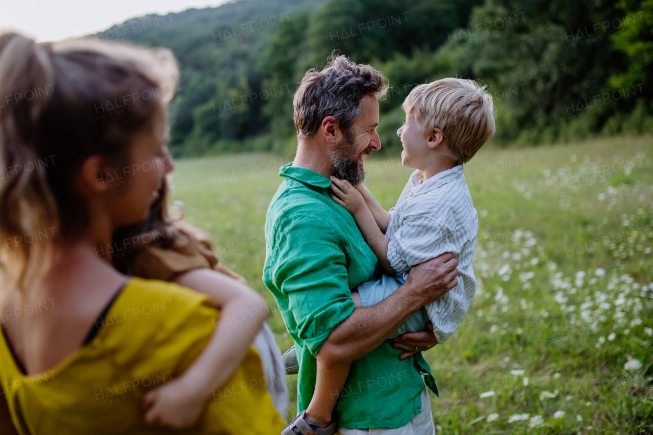 A happy young family spending time together outside in green nature.