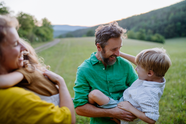 A happy young family spending time together outside in green nature.