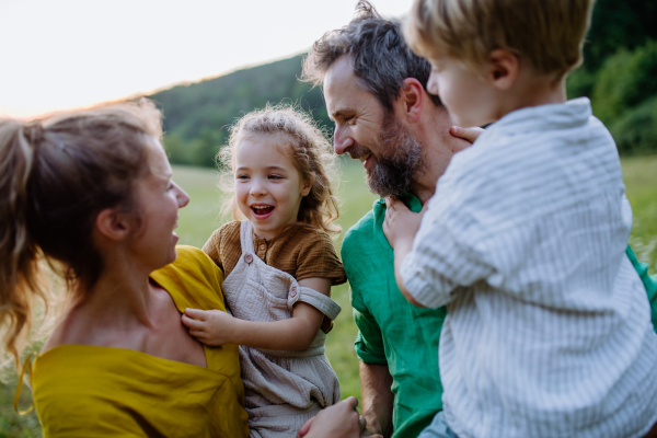 A happy young family spending time together outside in green nature.