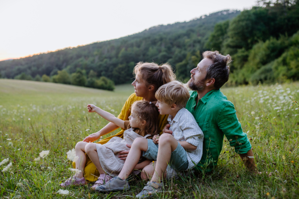 A happy young family spending time together outside in green nature.