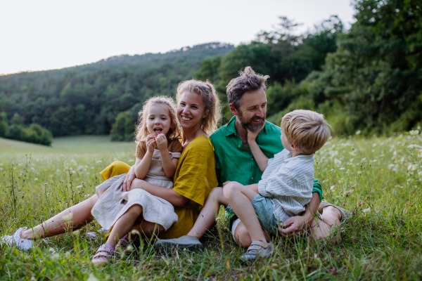 A happy young family spending time together outside in green nature.