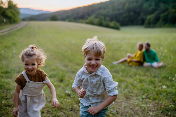 A happy young family spending time together outside in green nature.