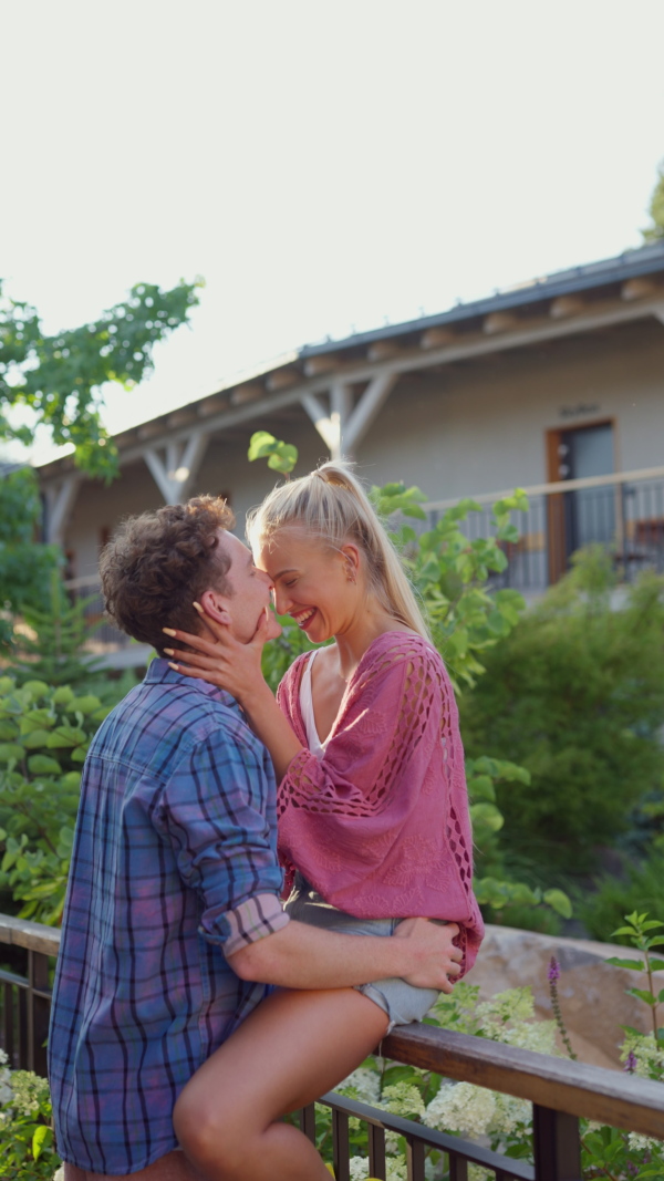 A young couple at vacation enjoying time for their-self, hugging in hotel resort, during sunset.