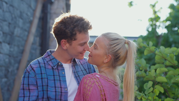 A young couple at vacation enjoying time for their-self, hugging in hotel resort, during sunset.